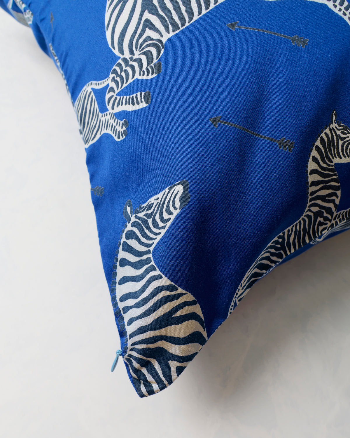Close-up of the blue zebra-and-arrow pillowcase corner with its zipper visible.