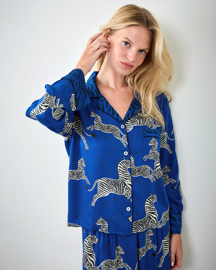 Person modeling a blue zebra-print button-front pajama shirt with long sleeves and matching pants.