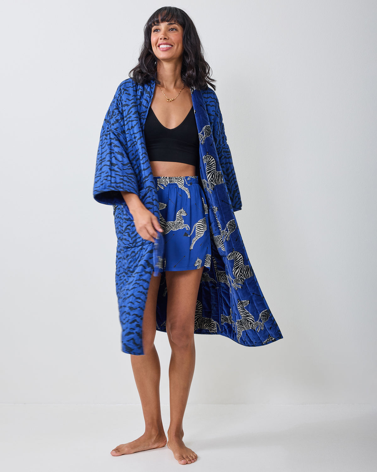 Blue quilted zebra-print robe worn open, showing the printed inner panel and matching shorts.