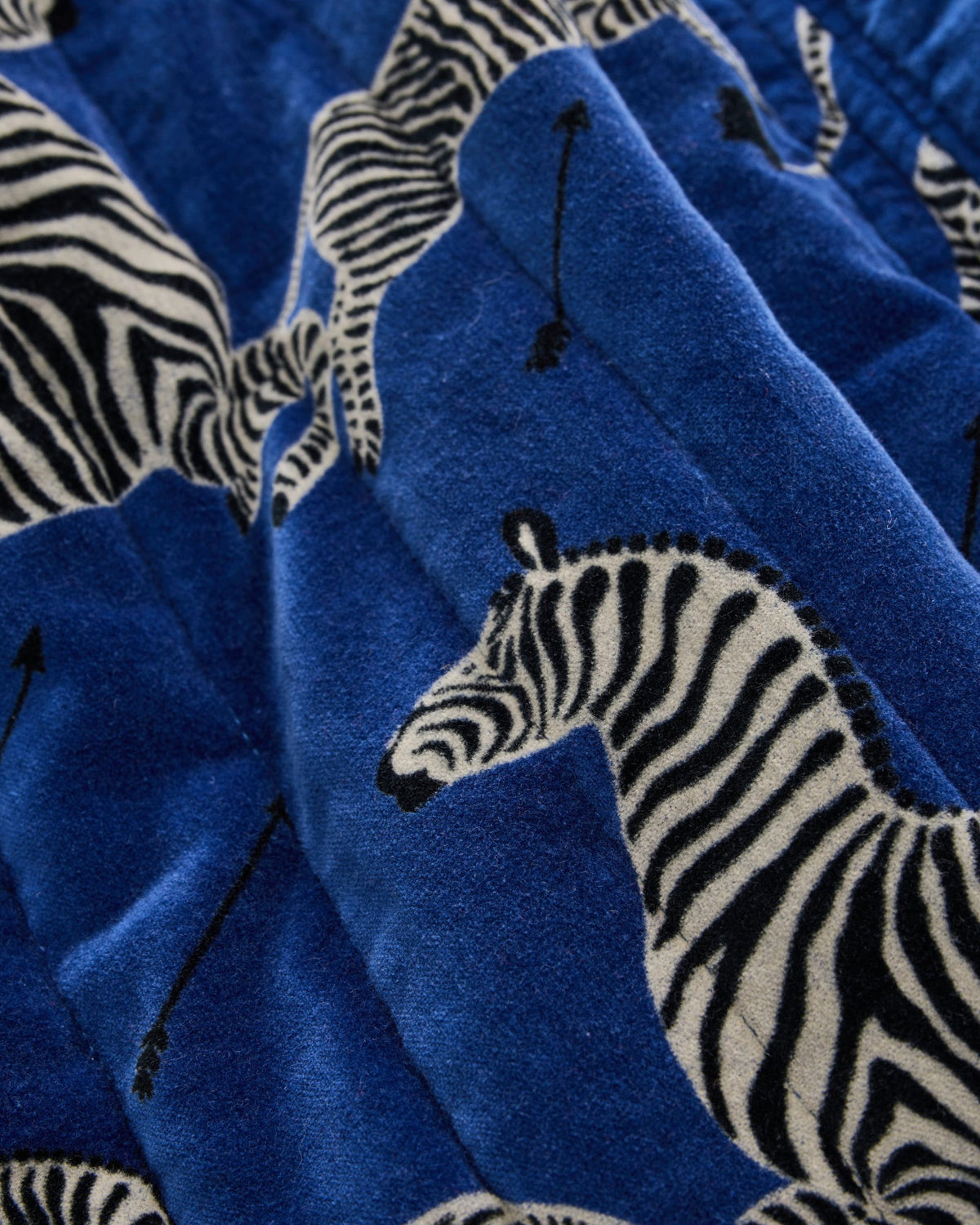Close-up of blue quilted robe fabric with a zebra print.