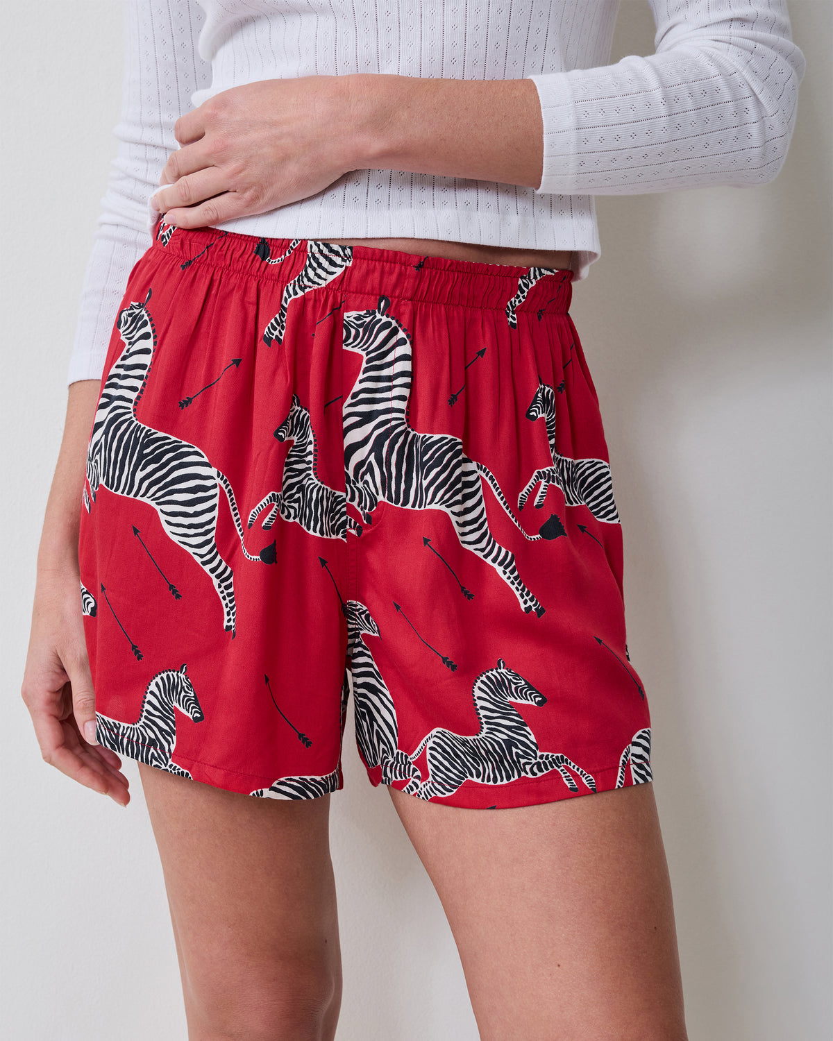 Close-up front view of red boxer shorts with an elastic waistband and black-and-white zebra print.