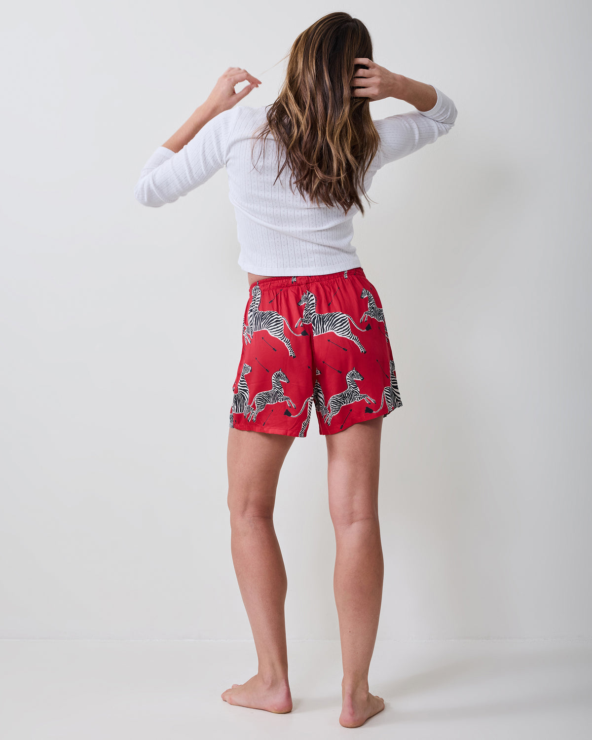 Back view of a person wearing red boxer shorts with a black-and-white zebra print.