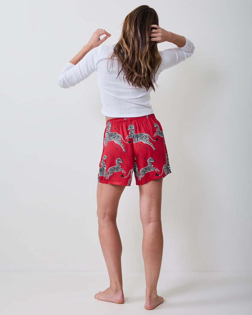 Back view of a person wearing red boxer shorts with a black-and-white zebra print.