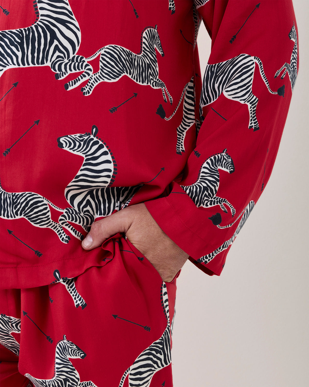 Close-up of the red zebra-print pajama shirt and pants, showing a hand in the pants pocket.