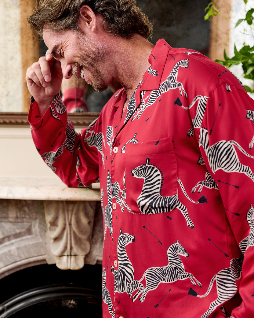 Close-up of the red pajama shirt showing its collar, buttons, chest pocket, and zebra print.