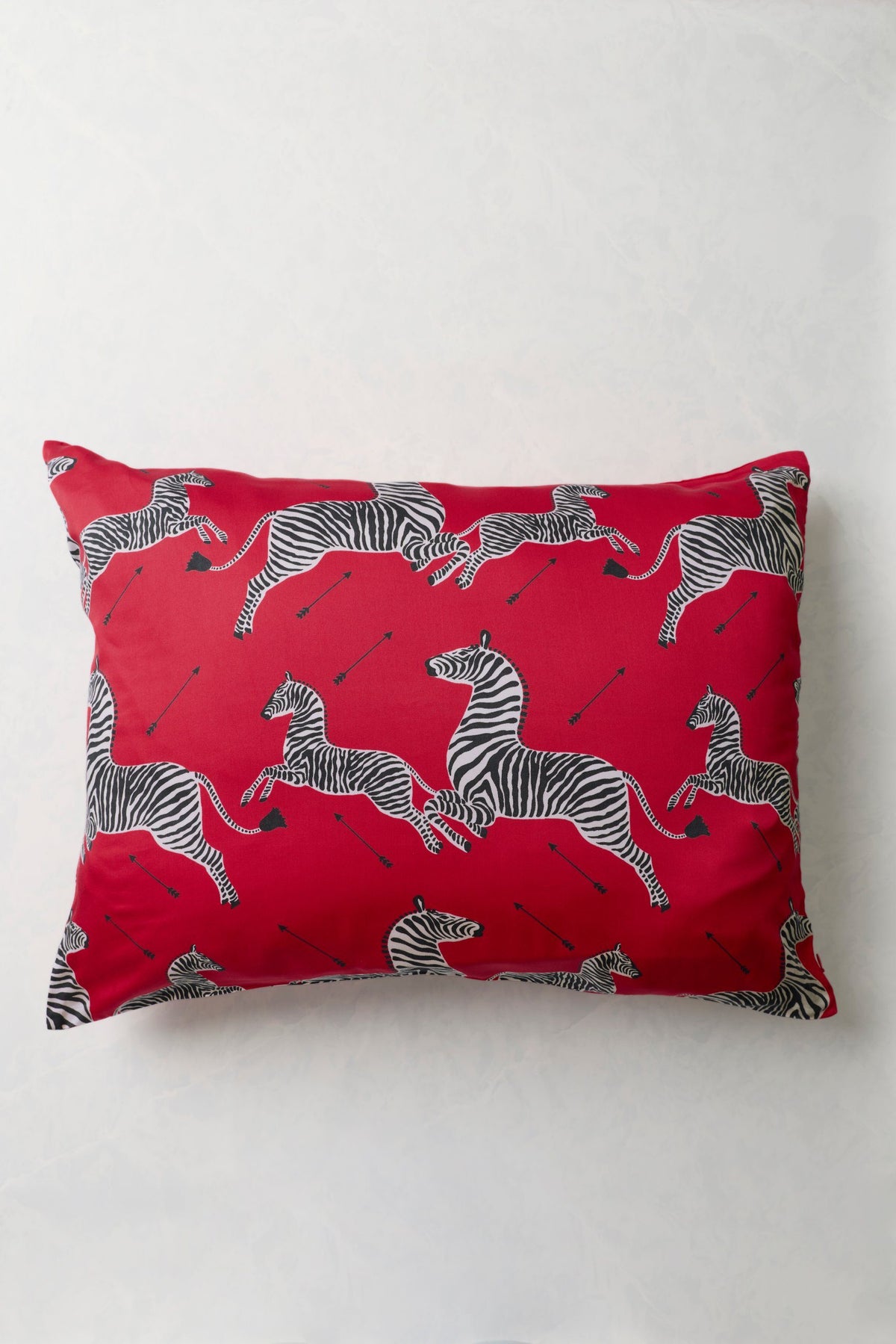 Red eco satin pillowcase with a repeated black-and-white zebra print, shown flat.
