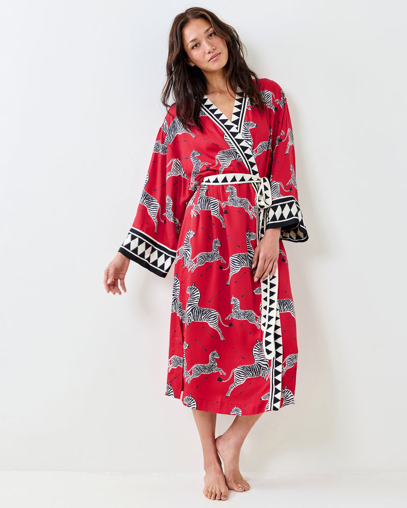 Front view of a person wearing a red zebra-print robe with a tied waist belt and geometric trim.