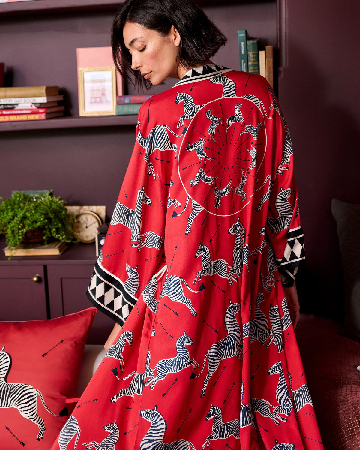 Back view of a red robe with a black-and-white zebra print and geometric sleeve trim.