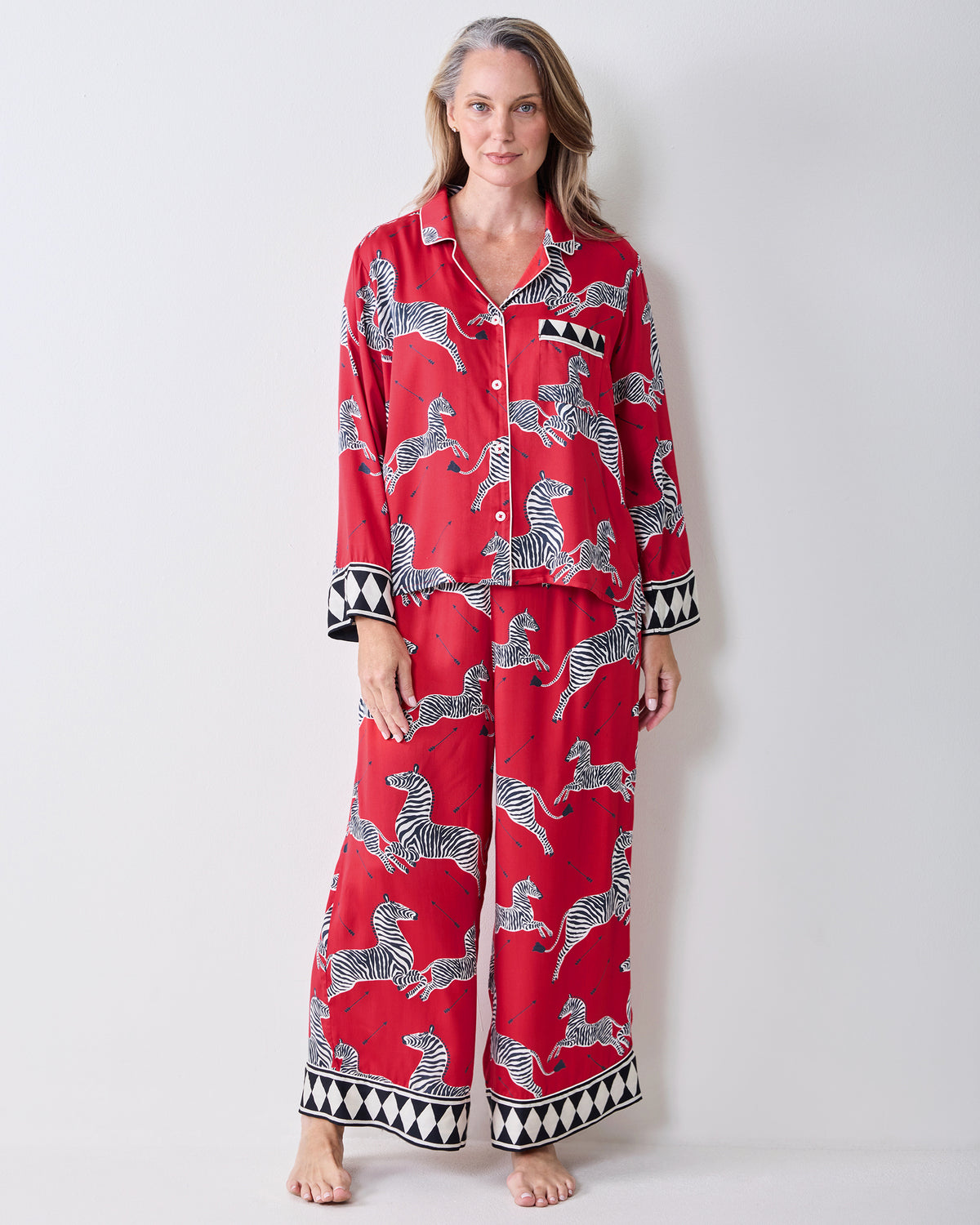 Front view of a person wearing the red zebra-print Soho pajama set with geometric trim.