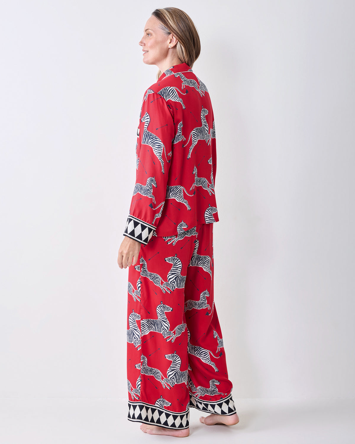Back three-quarter view of a person wearing the red zebra-print pajama set, showing the shirt and pant backs.