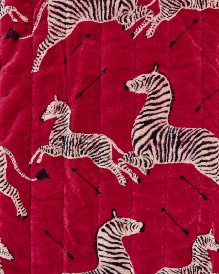 Close-up of the red quilted pouch surface with zebra and arrow prints.