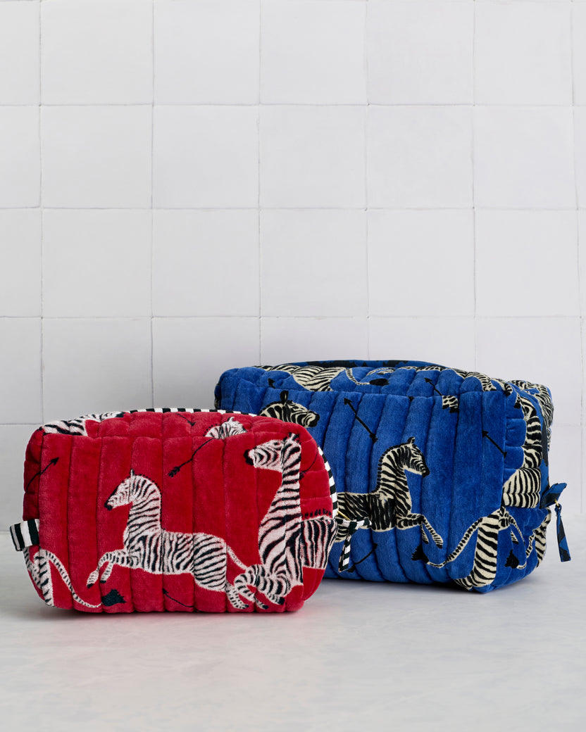Red and blue quilted pouches with repeated zebra print shown side by side.