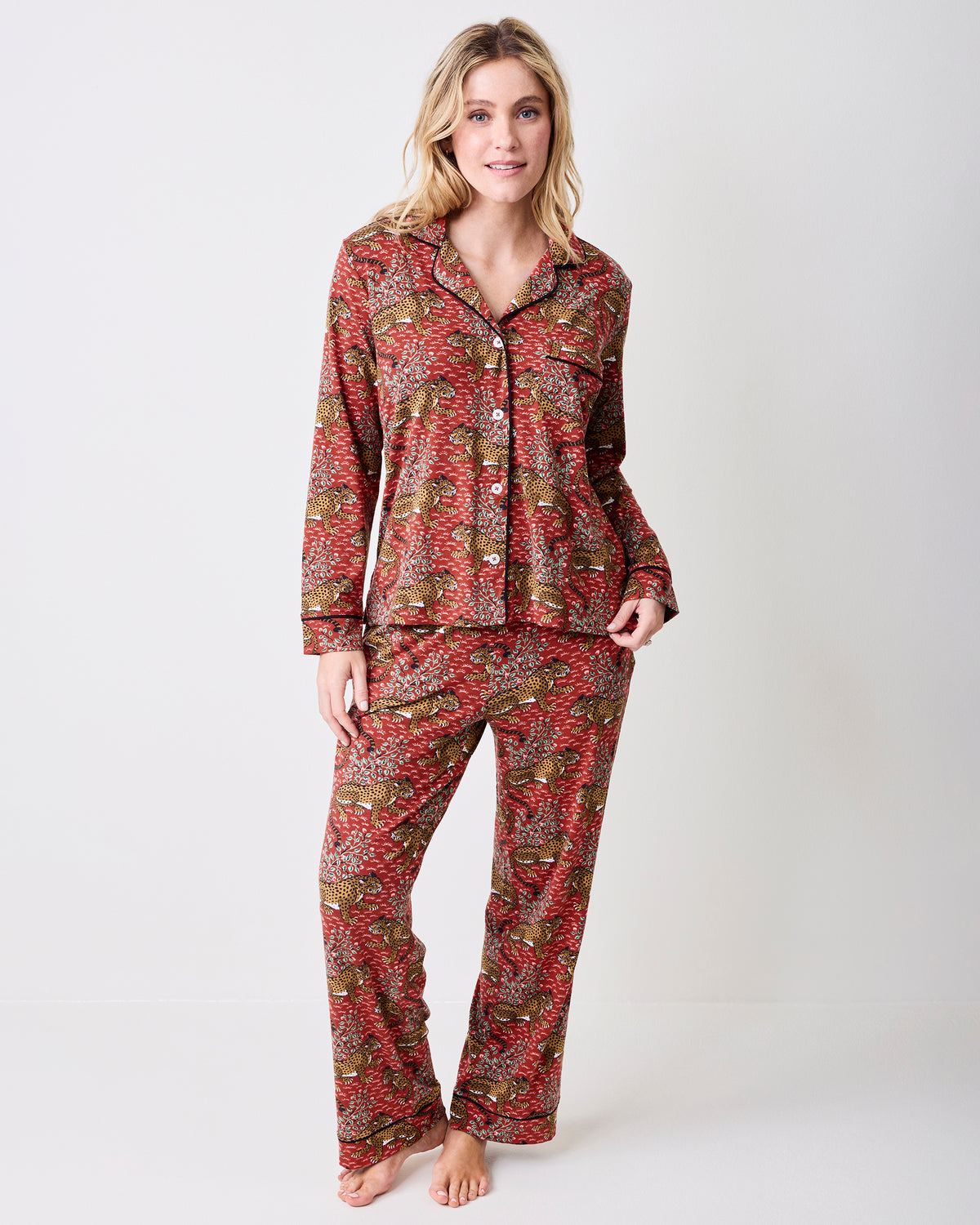 Full view of the scarlet Bagheera long pajama set with a collared button-front top and matching pants in a leopard-and-leaf print.