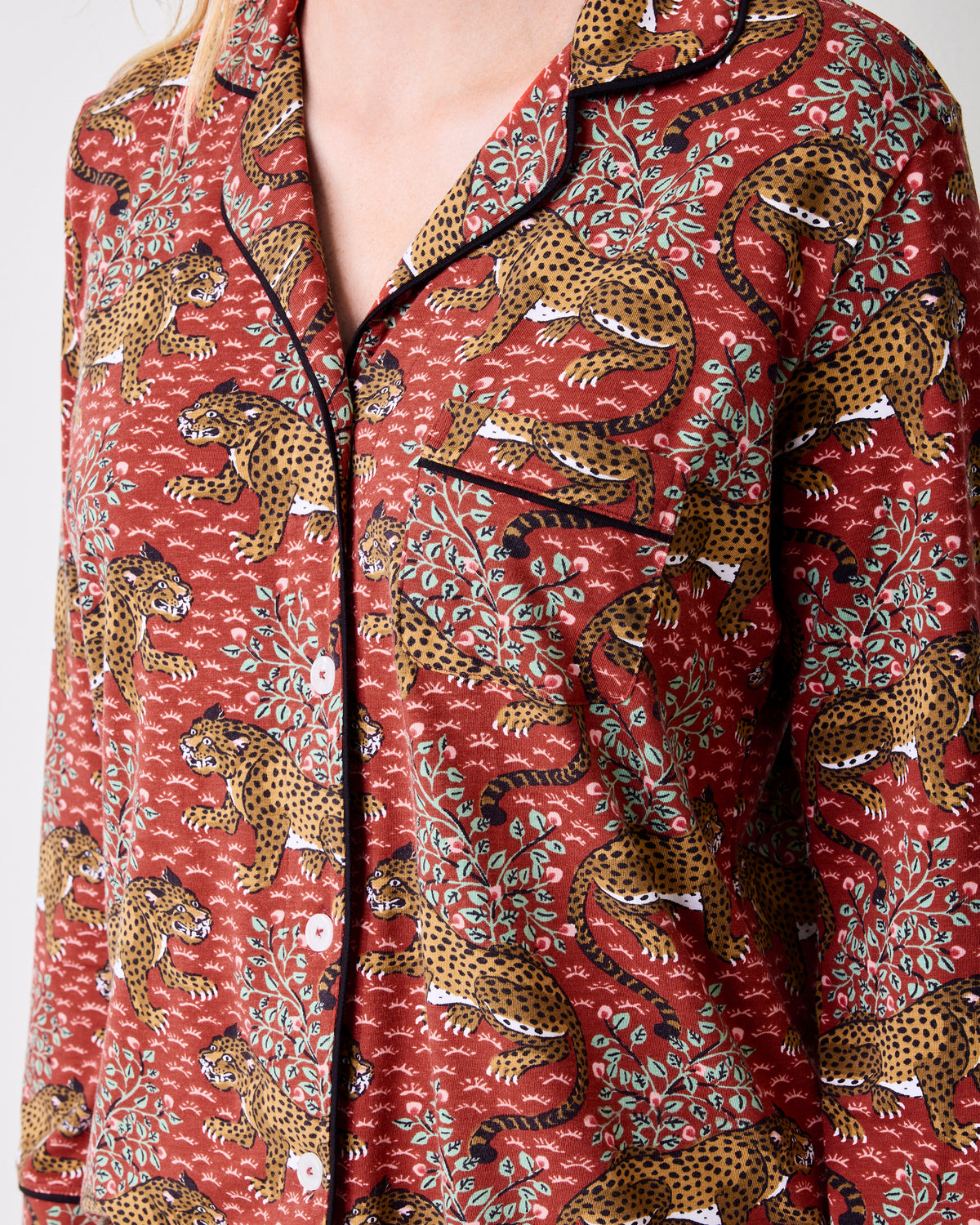 Close-up of the scarlet Bagheera long pajama top with leopard-and-leaf print, black piping, and button front.