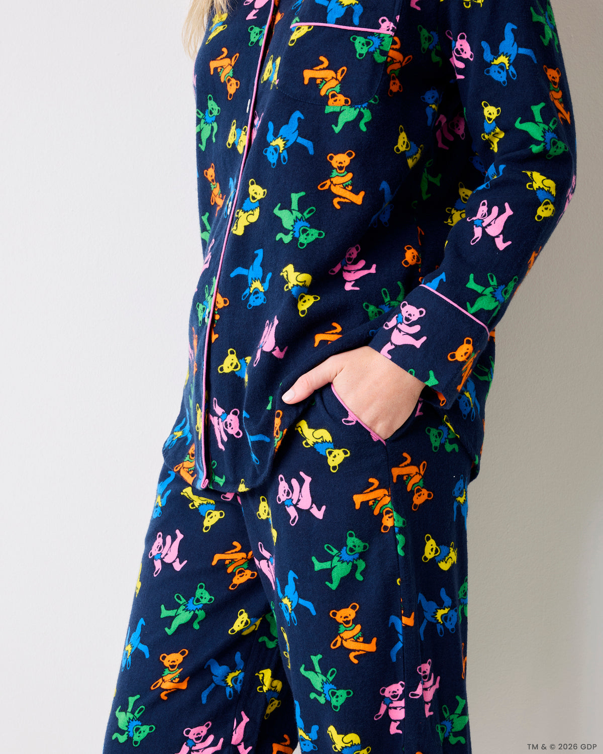 Side view of a navy Dancing Bears pajama set with colorful bear prints, shirt pockets, and pants pockets.