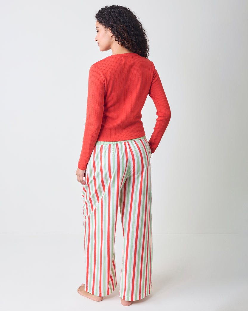 Rear three-quarter view of Elf Stripes Nola pajama pants with vertical sage and cherry stripes and an elastic waistband.