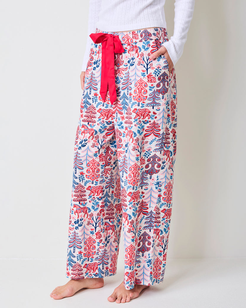 Close front view of cream Folklore Forest printed pajama pants showing the red drawstring and side pockets.