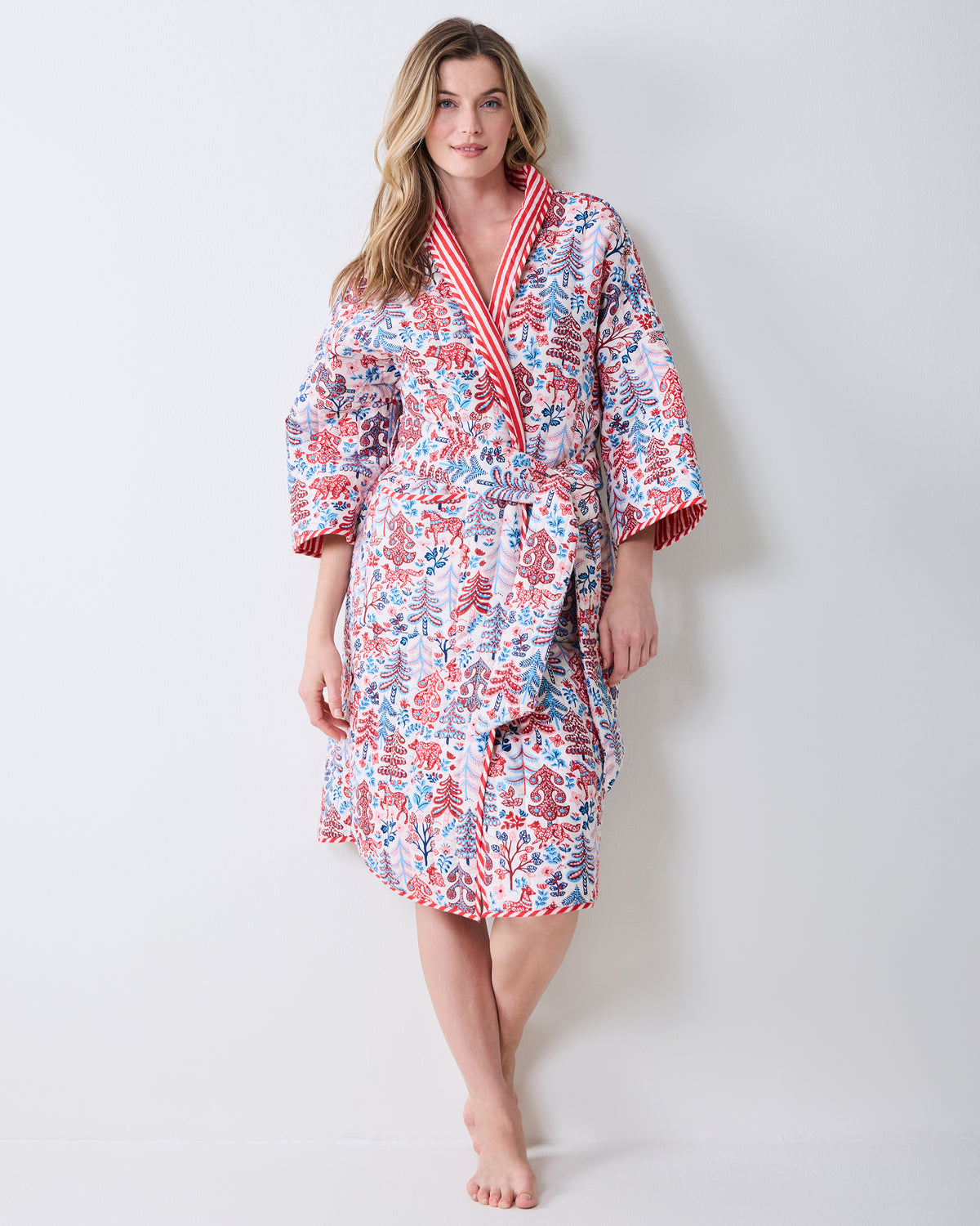 Full front view of the cream reversible robe with a red and blue forest-inspired print, striped trim, and tie belt.