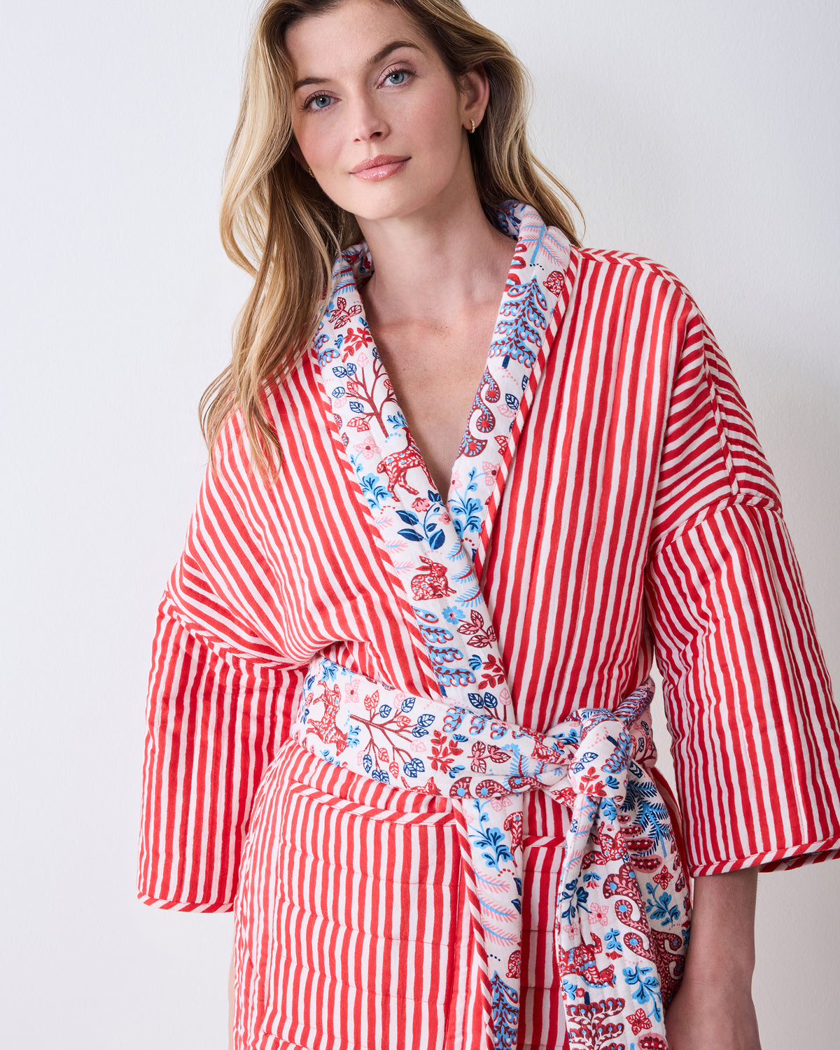 Front view of a Folklore Forest reversible quilted robe, showing red-and-white striped trim, patterned collar, and matching belt.