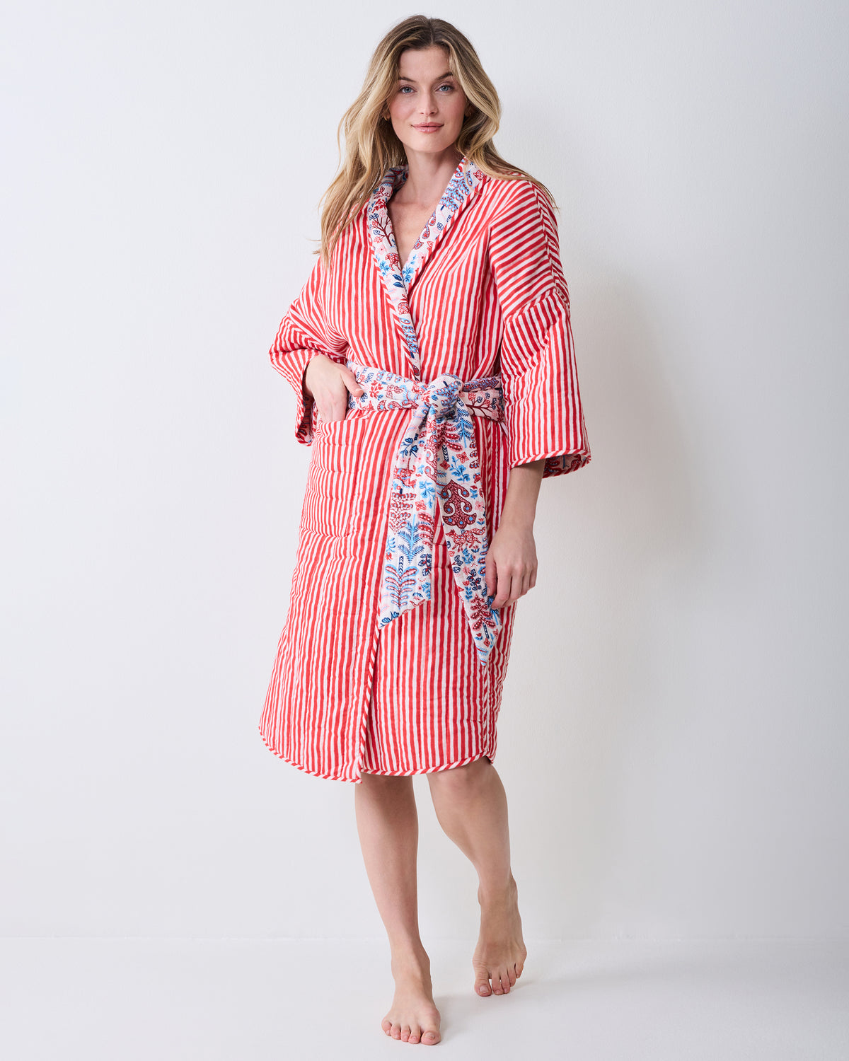 Front view of the reversible robe showing its red-and-white striped side, patterned trim, and tie belt.