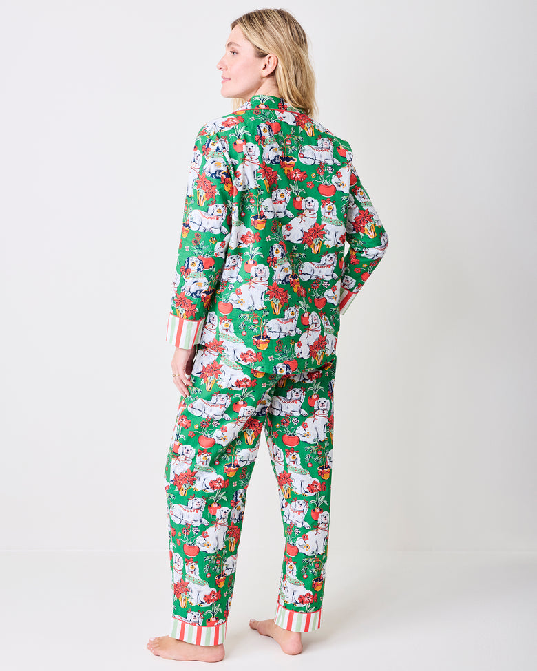 Back view of a person wearing the Good Dog Christmas evergreen long pajama set with a dog-and-holiday print and striped cuffs.