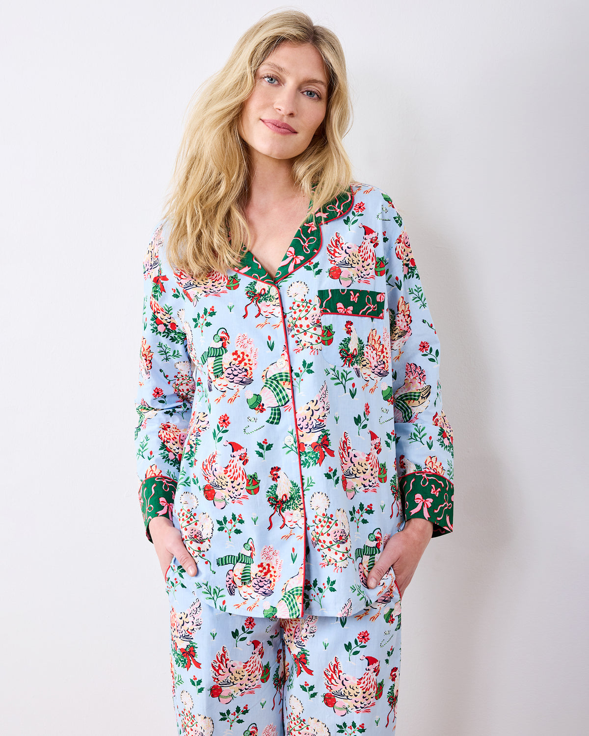 Person wearing a pale blue long-sleeve pajama set with a colorful holiday hen print.