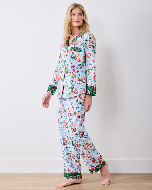 Side view of a person wearing the pale blue Holiday Hens Tall long pajama set with matching button-front top and full-length pants.