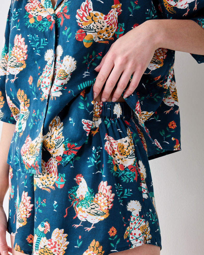 Close-up of the Holiday Hens pajama set showing the top hem and elastic waistband of the matching shorts.