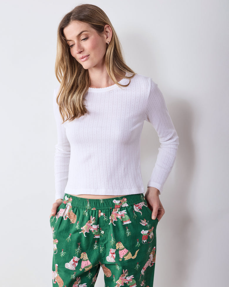 Front view of green printed joggers with an elastic waistband and gathered ankle cuffs, worn with a white long-sleeve top.