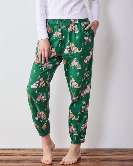 Front close-up of green printed joggers showing the elastic waistband, side pocket, relaxed legs, and gathered ankle cuffs.