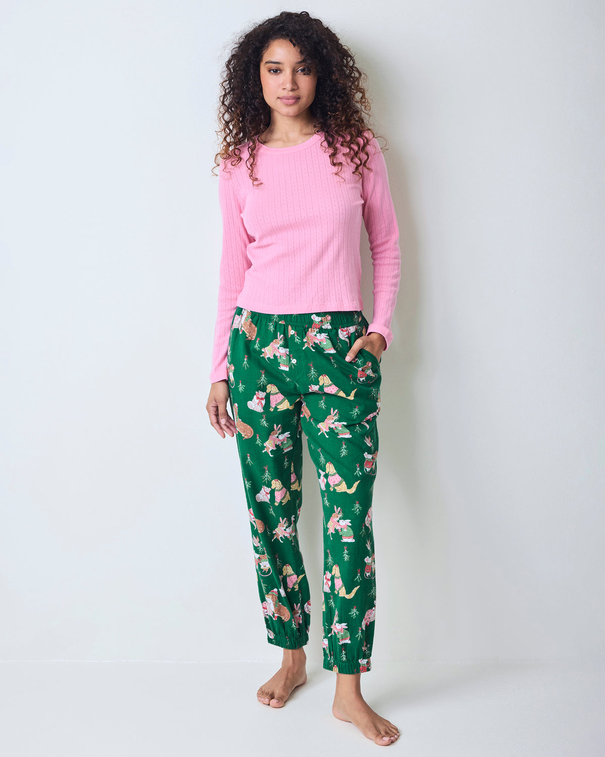 Full-length front view of a model wearing green printed joggers with a pink long-sleeve top and gathered ankle cuffs.