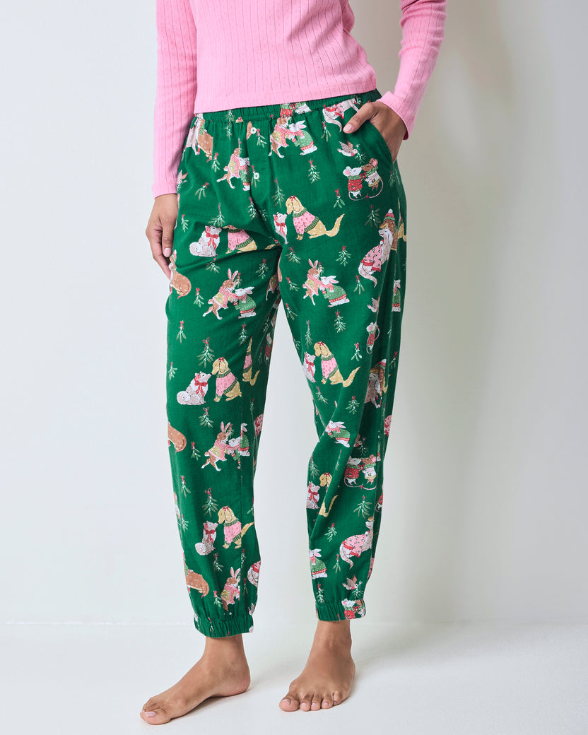 Front close-up of green printed joggers showing the elastic waistband, side pockets, and gathered ankle cuffs.