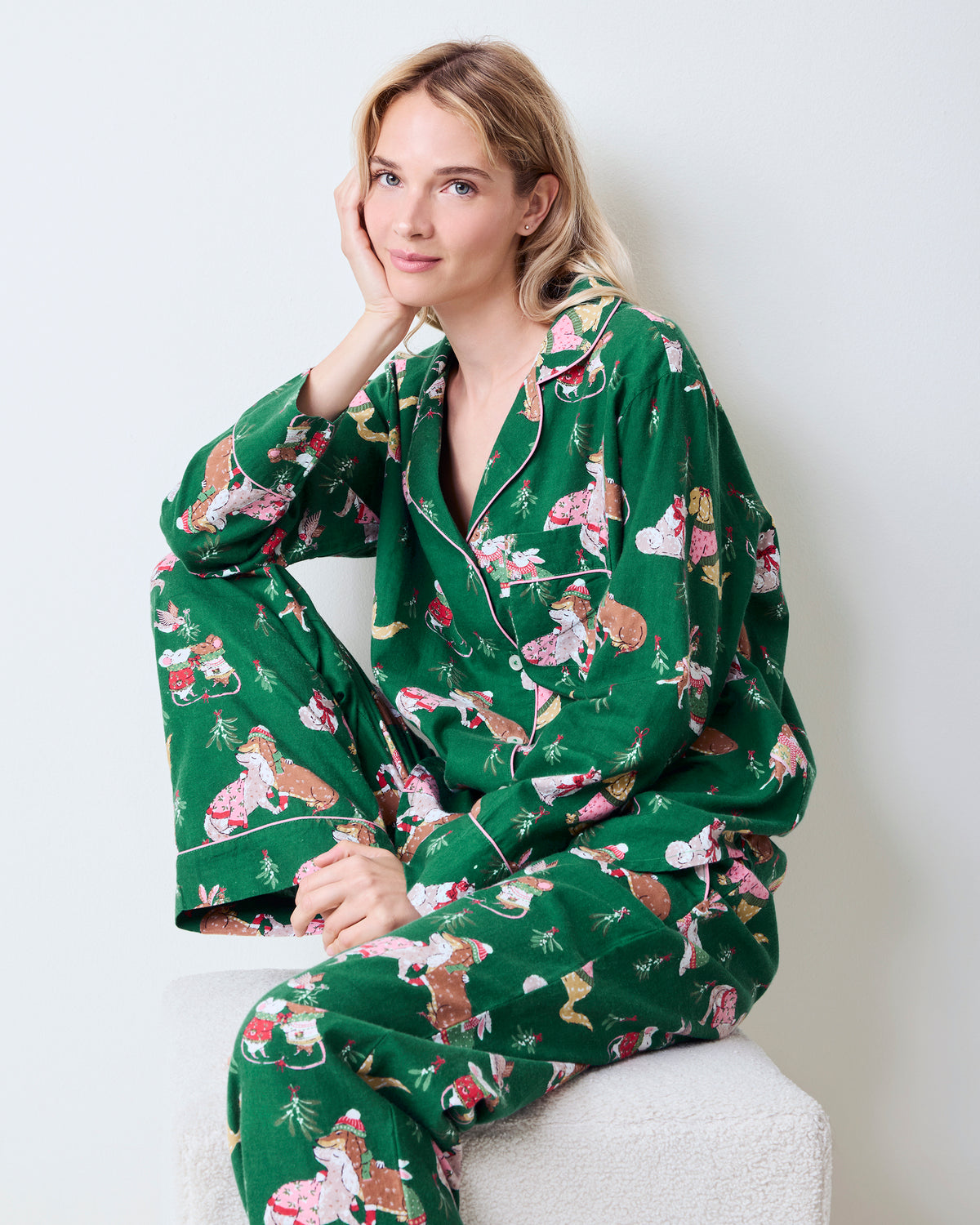 Person seated wearing the green Mistletoe Kiss flannel pajama set, showing the collared button-down top and long pants.