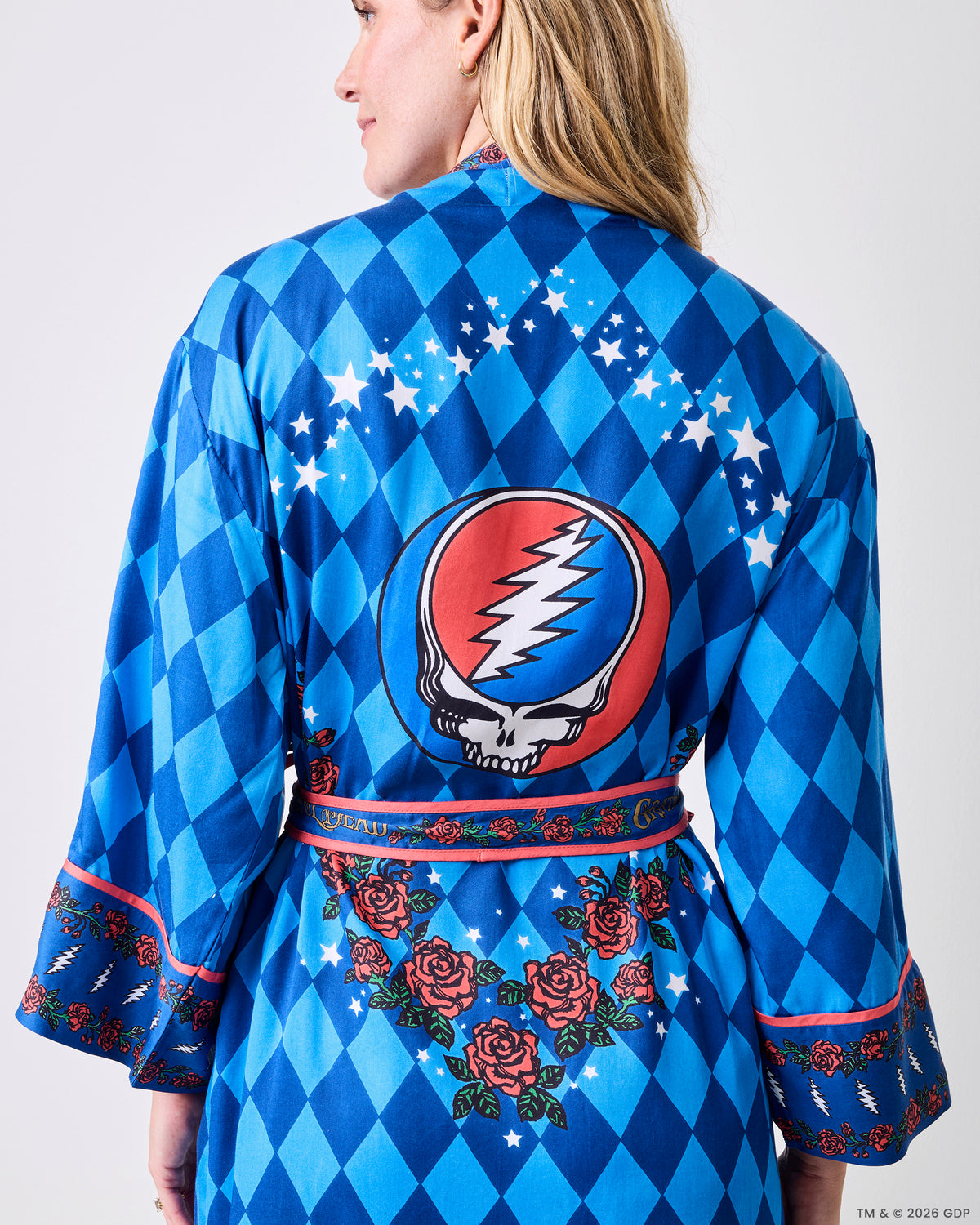 Back view of the blue patterned robe showing the large circular lightning-bolt-and-skull graphic, star arc, rose border, and wide cuffs.