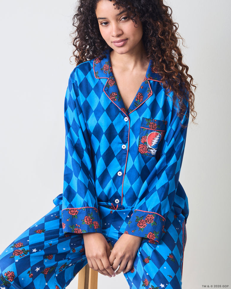 Front view of the blue argyle long pajama set, showing the rose-patterned collar and cuffs and skull-and-lightning chest pocket.