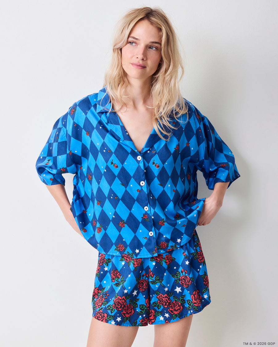 Front view of the blue patterned Eco Satin Sweet Dreams Set with a button-front top, three-quarter sleeves, and matching shorts with a rose-and-star print.