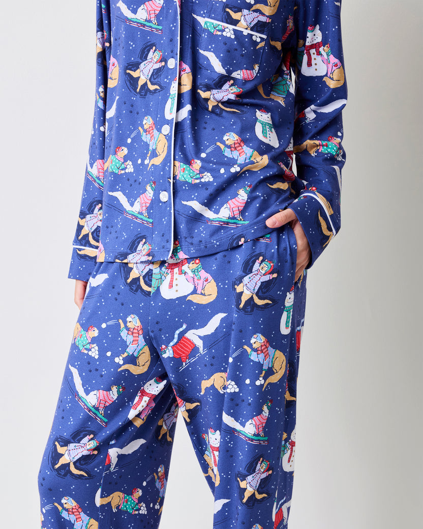 Close-up of the blue pajama top and pants showing white piping, a pocket, and the winter print.