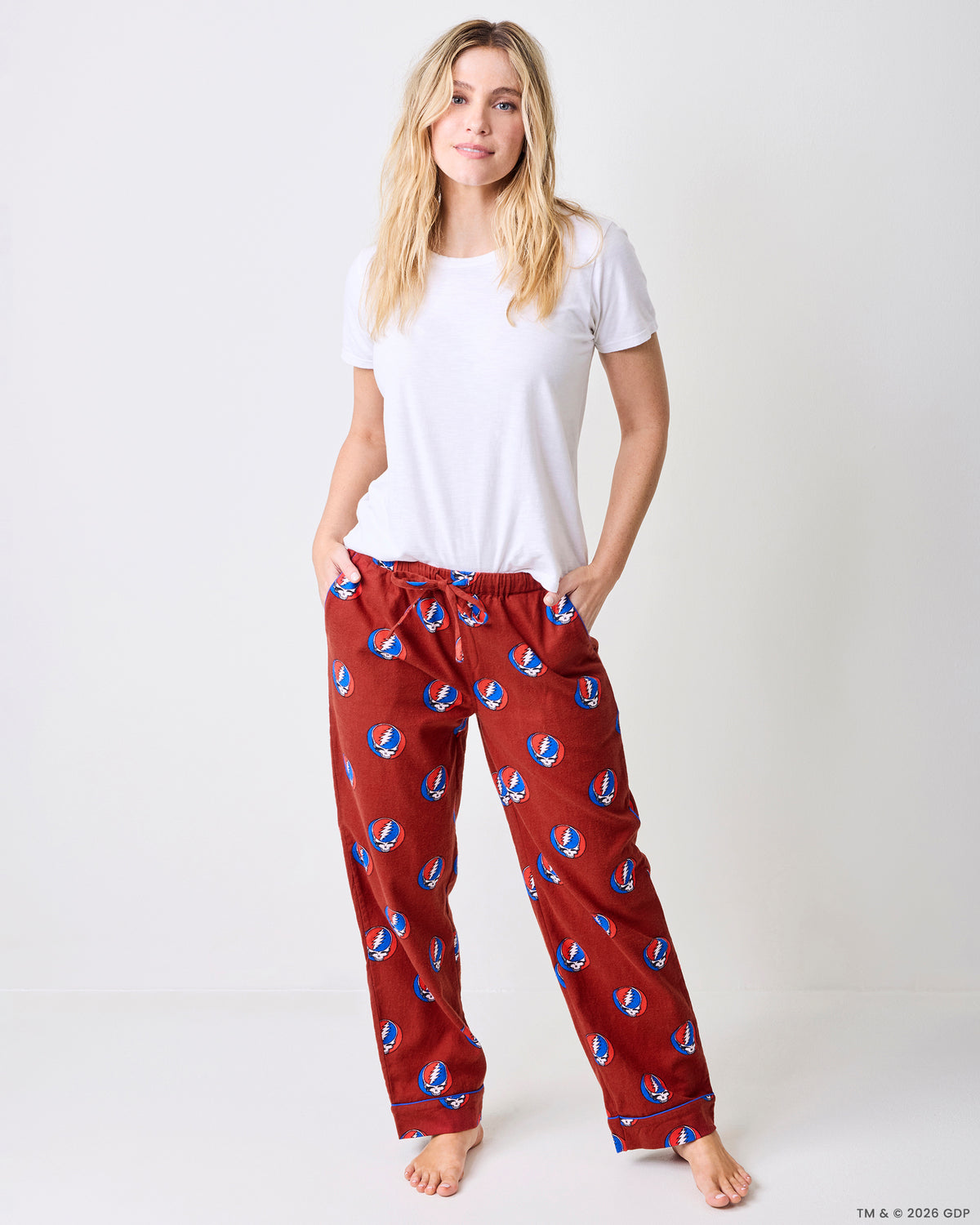 Front view of red pajama pants with a white short-sleeved shirt, showing the drawstring waist and skull-and-lightning-bolt print.