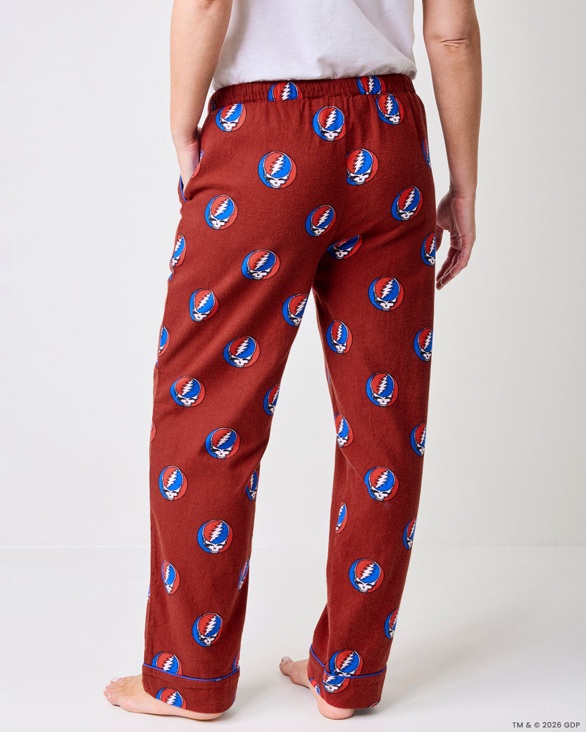 Back view of red full-length pajama pants with a drawstring waist, cuffed hems, and skull-and-lightning-bolt print.