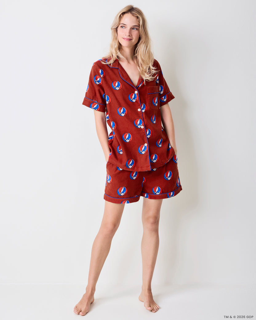 Front view of a red short-sleeve pajama set with a blue, red, and white skull-and-lightning-bolt print.