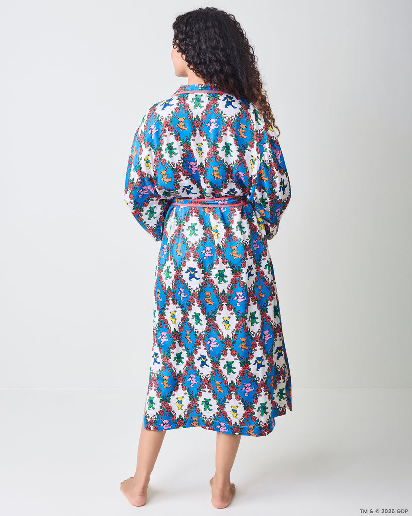 Back view of a long robe with wide sleeves, a tied waist, and a blue-and-white bear-and-rose print.