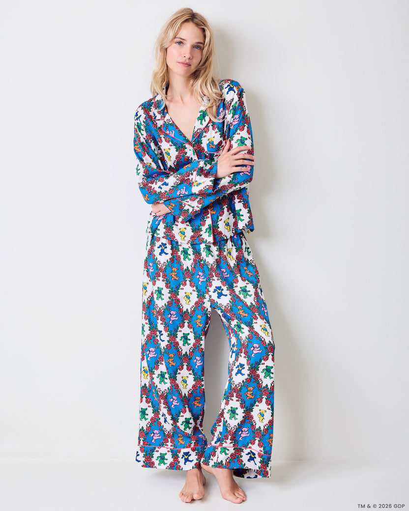 Model standing against a wall wearing the long-sleeved bear-and-rose print pajama set.