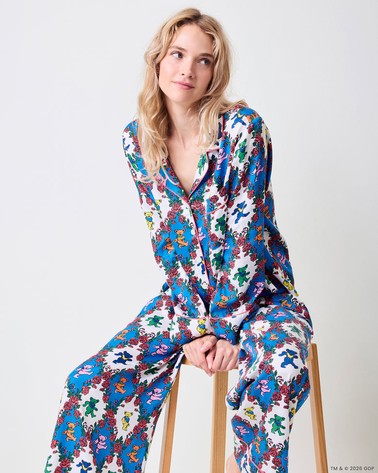 Seated full-length view of the Wandering Rose Palo Alto Soho set with a collared top and wide-leg pants in the rose and dancing-bear print.