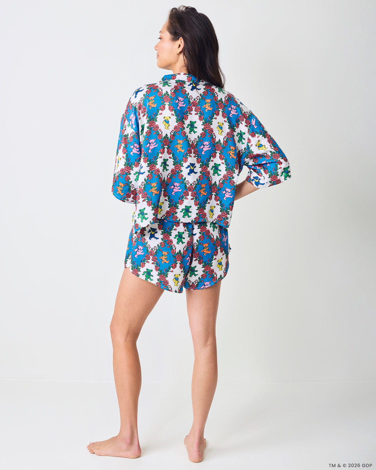 Back view of a short-sleeve top and matching shorts with a blue-and-white bear-and-rose print.