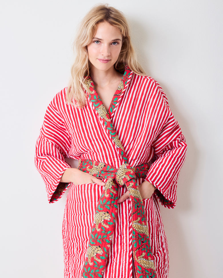 Front view of the striped side of a reversible quilted robe, with leopard-print trim and matching belt.