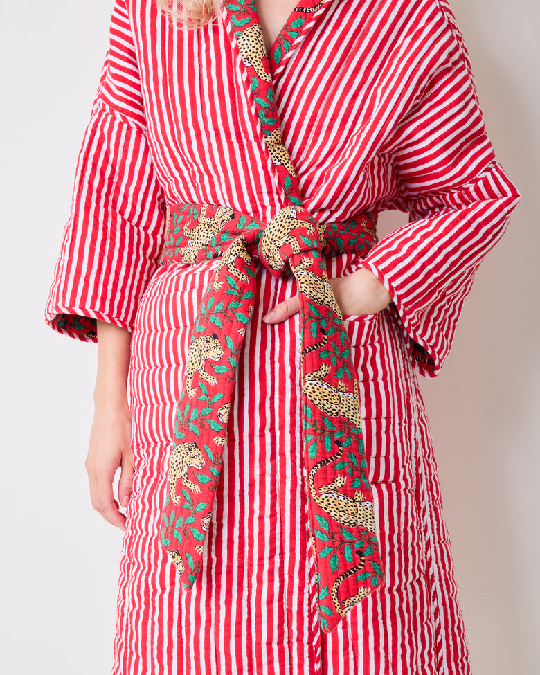 Close-up of the striped side of a reversible quilted robe showing leopard-print trim, belt, and side pocket.