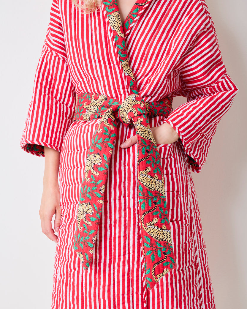 Close-up of the striped side of a reversible quilted robe showing leopard-print trim, belt, and side pocket.