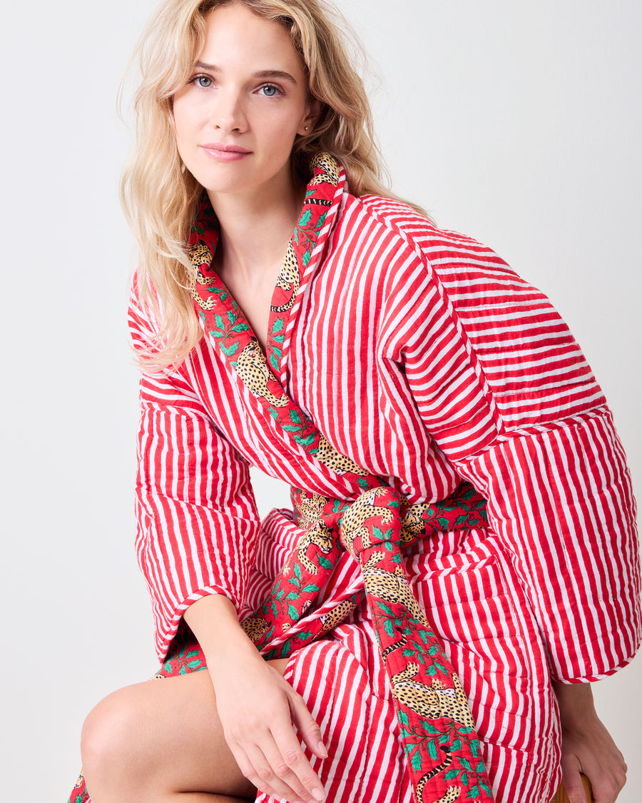 Ruby quilted robe with red-and-white striped lining, leopard-print floral trim, matching belt, and pockets, shown from the front
