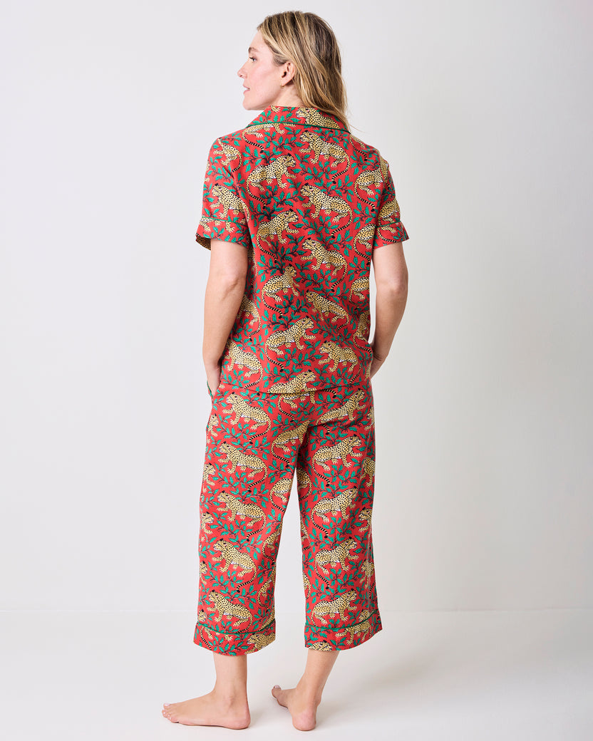 Back view of a person wearing the red Winter Holly Bagheera pajama set with a short-sleeve top and cropped pants.