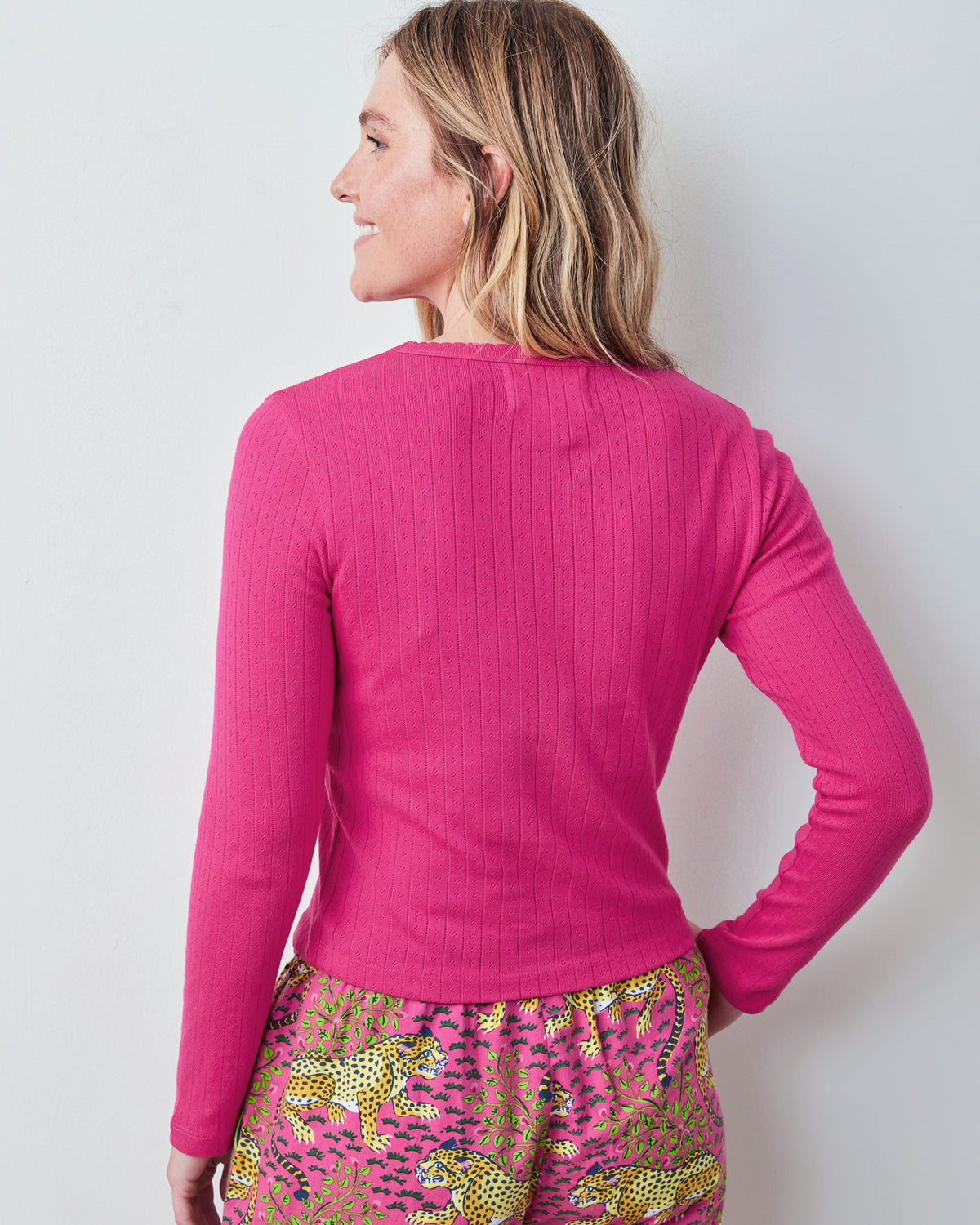 Back view of a bright pink long-sleeve pointelle shirt